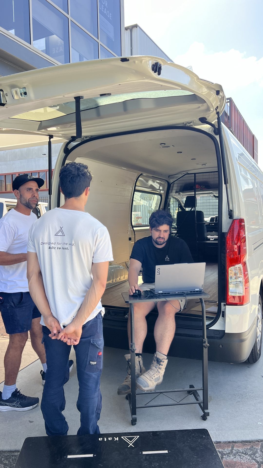 The Kata team working from the open back of a van