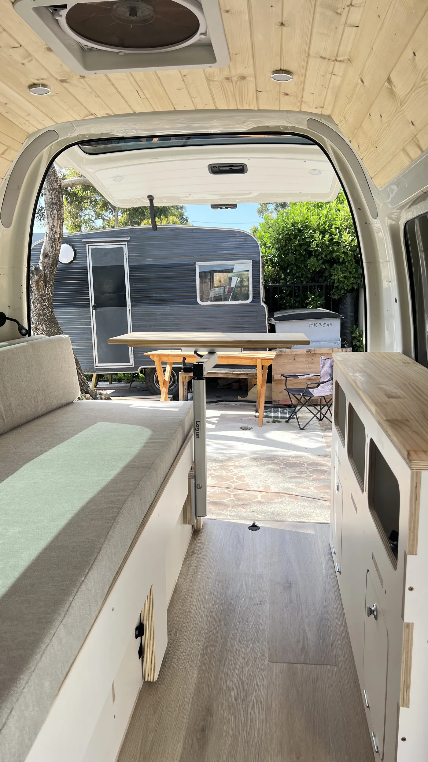A converted Toyota Hiace set up at camp at dusk with the awning out